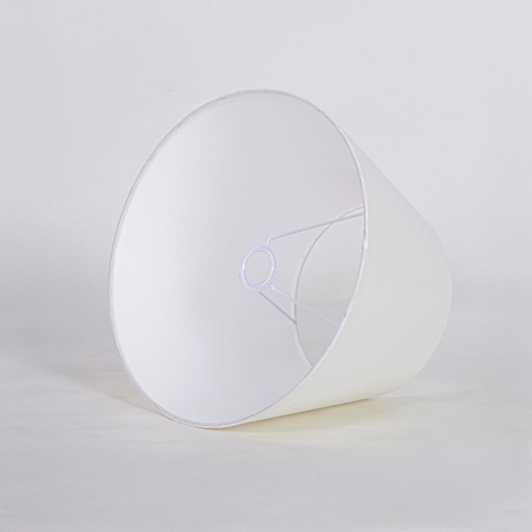 White tapered fabric lamp shade for modern table lamp styling and elegant interior lighting decor placement.