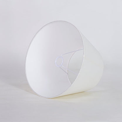 White tapered fabric lamp shade for modern table lamp styling and elegant interior lighting decor placement.