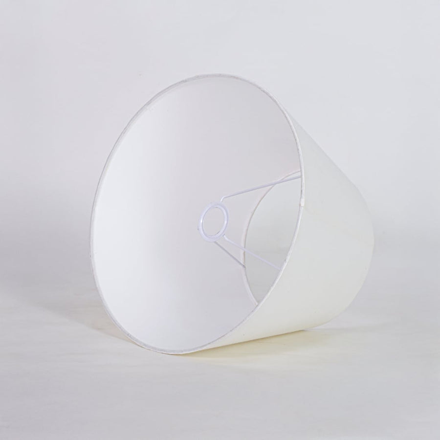 White tapered fabric lamp shade for modern table lamp styling and elegant interior lighting decor placement.