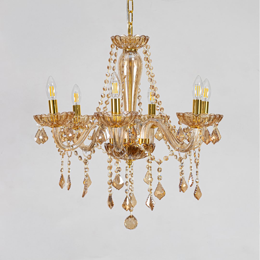 Golden crystal chandelier with decorative beads displayed on white background perfect for classic interior ceilings.