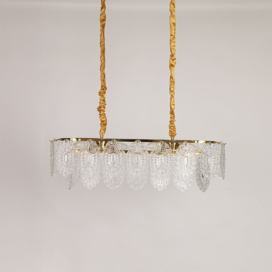 Gold metal chandelier with decorative glass detailing displayed with lights off on a white background showcasing its vintage ornate design.