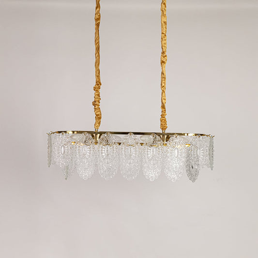 Gold metal chandelier with decorative glass detailing displayed with lights off on a white background showcasing its vintage ornate design.