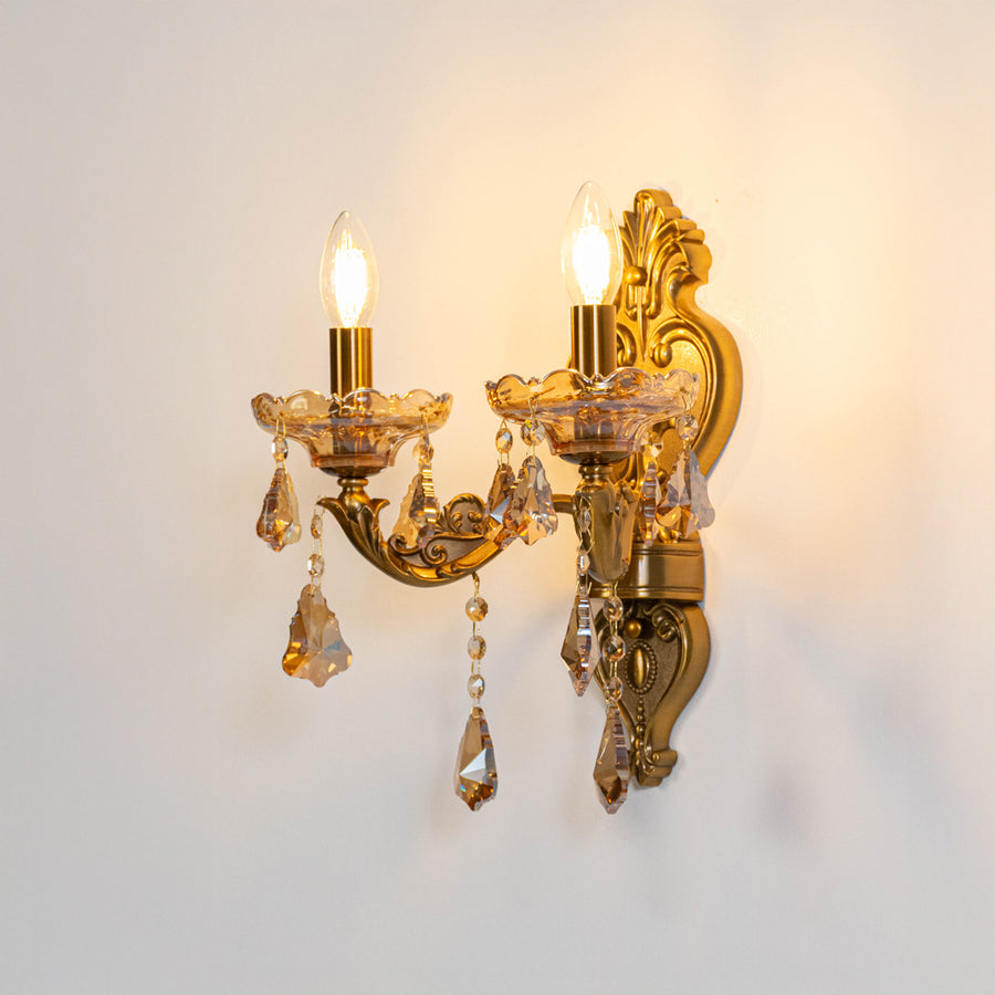 Vintage metal wall light in gold finish with candle bulbs and crystals for bedroom or living decor lighting white background.