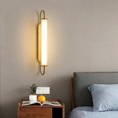 Gold metal wall light lifestyle image with warm LED glow for elegant modern bedroom interior decor.