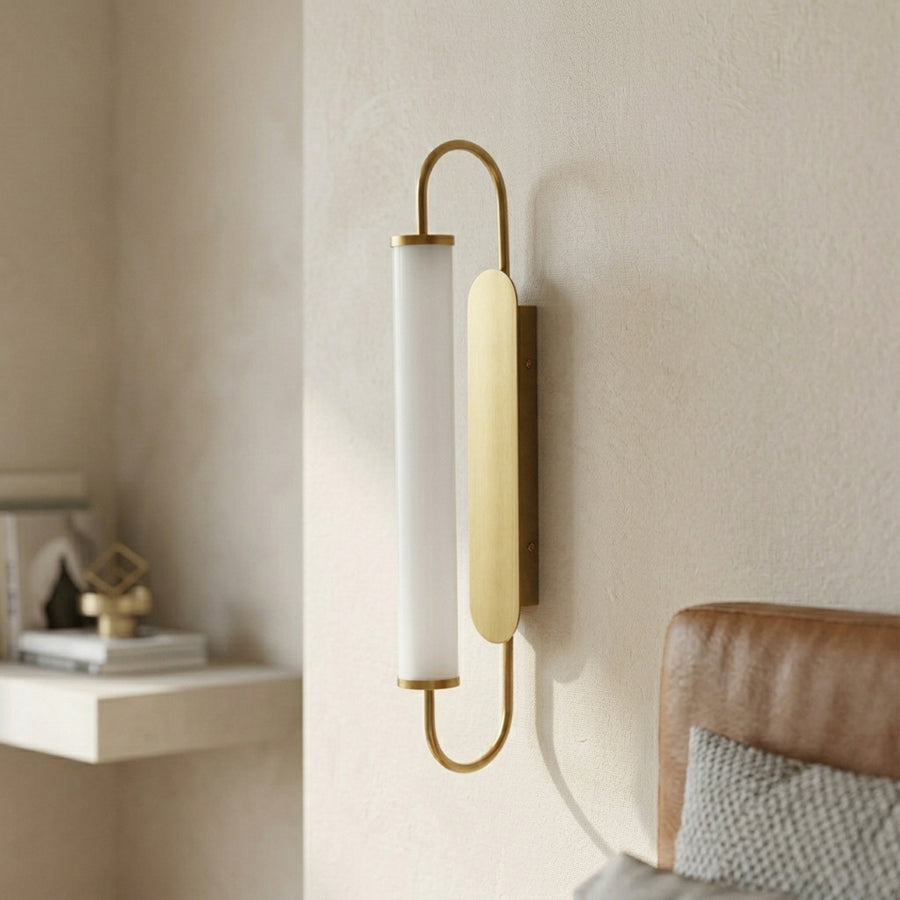 Gold metal wall light lifestyle image with frosted glass shade for cozy modern bedroom wall decor.