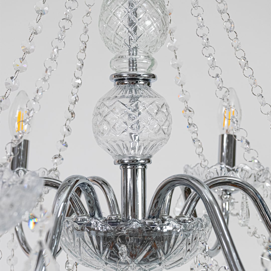 Closeup of silver metal crystal chandelier with detailed crystal drops and curved arms perfect for luxury ceiling decor.