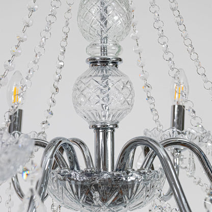 Closeup of silver metal crystal chandelier with detailed crystal drops and curved arms perfect for luxury ceiling decor.