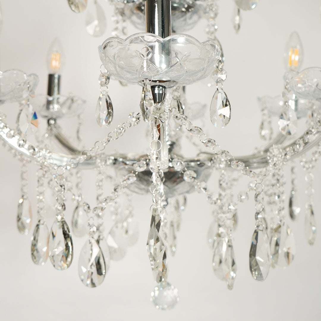 Closeup image of waterfall crystal chandelier for luxury living room decor styling with polished finish.