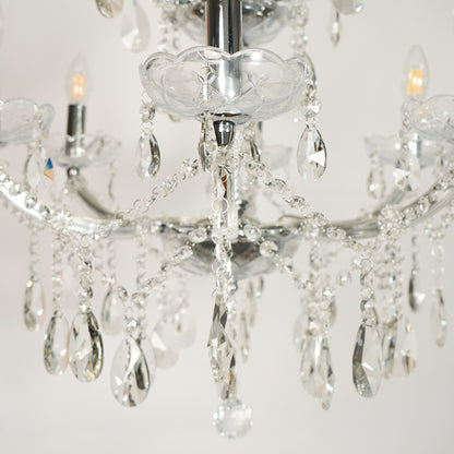 Closeup image of waterfall crystal chandelier for luxury living room decor styling with polished finish.