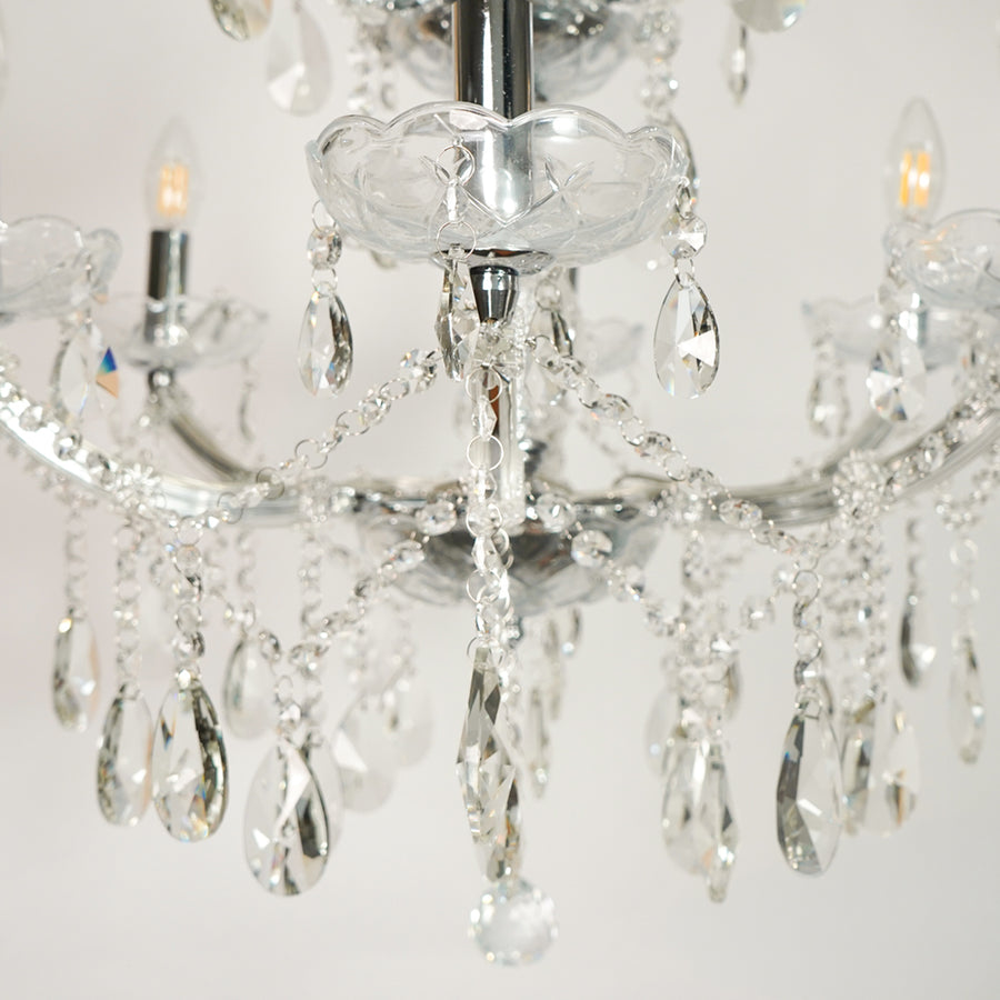 Closeup image of waterfall crystal chandelier for luxury living room decor styling with polished finish.
