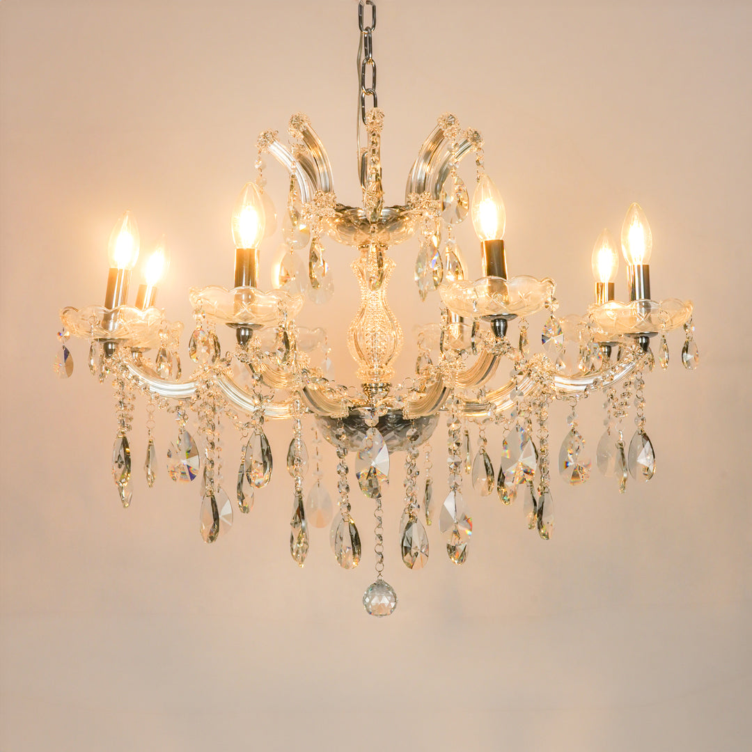 White background image of large waterfall crystal chandelier for modern living room decor styling with a bright warm glow.