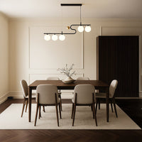 A sculptural black and gold chandelier shining softly above a neutral dining table arrangement adding refined warm LED lighting and sophisticated décor.