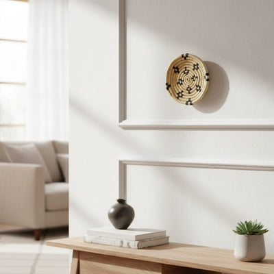 Round metal wall decor with intricate leaf inspired pattern styled above console table adding refined artistic character to modern neutral living space.