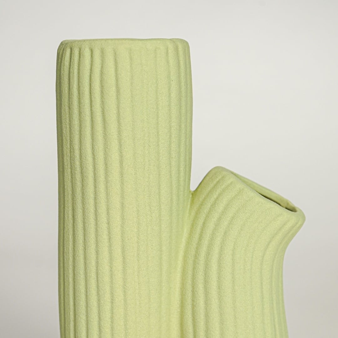 Detailed top view of light green ceramic vase showing twin openings and textured ribbed handmade surface.