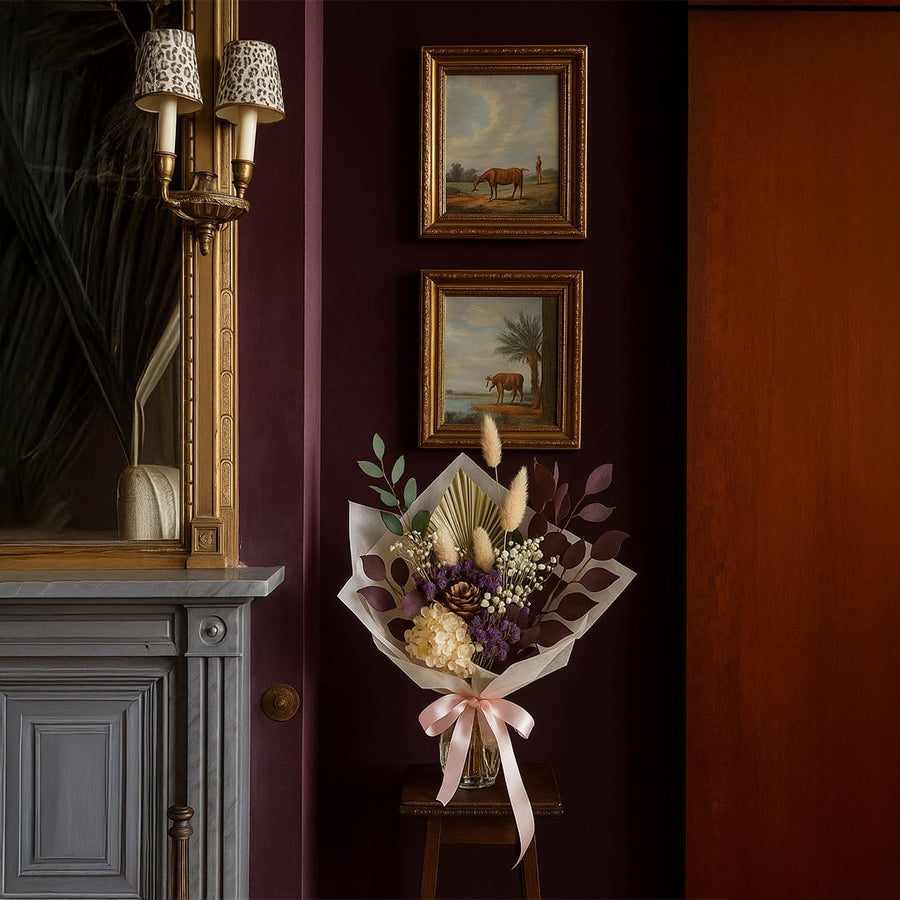 Dried floral arrangement styled in classic interior with framed artwork adding rich color and elegant focal point to home Decor.