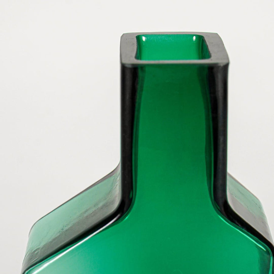Close up view green art glass vase showing smooth sculpted surface glossy finish decorative glass accent for shelf styling.