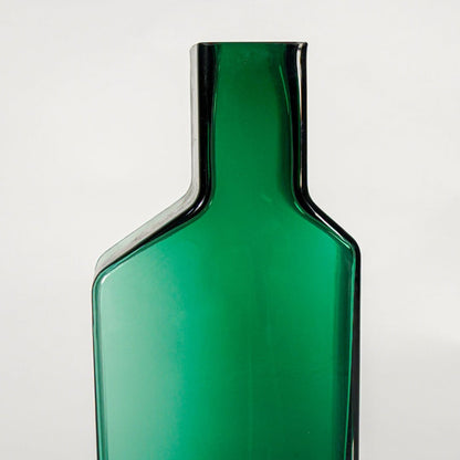 Close up view green art glass vase showing sharp geometric edges smooth glossy finish decorative glass accent for shelf styling home.
