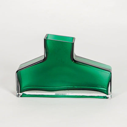 Green decorative art glass vase on white background modern home decor accent piece for table shelf console styling interior.