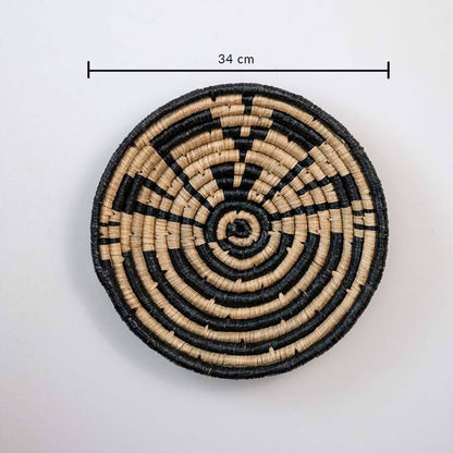 Handwoven seagrass round wall basket decor in natural beige and black with geometric spiral pattern and size guide.