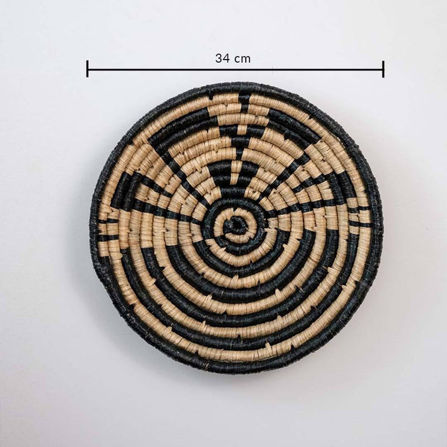 Handwoven seagrass round wall basket decor in natural beige and black with geometric spiral pattern and size guide.