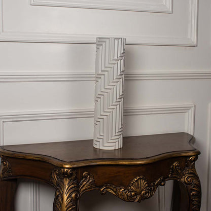Tall white geometric ceramic vase with embossed linear pattern displayed on a plain white background showcasing its elegant modern form.