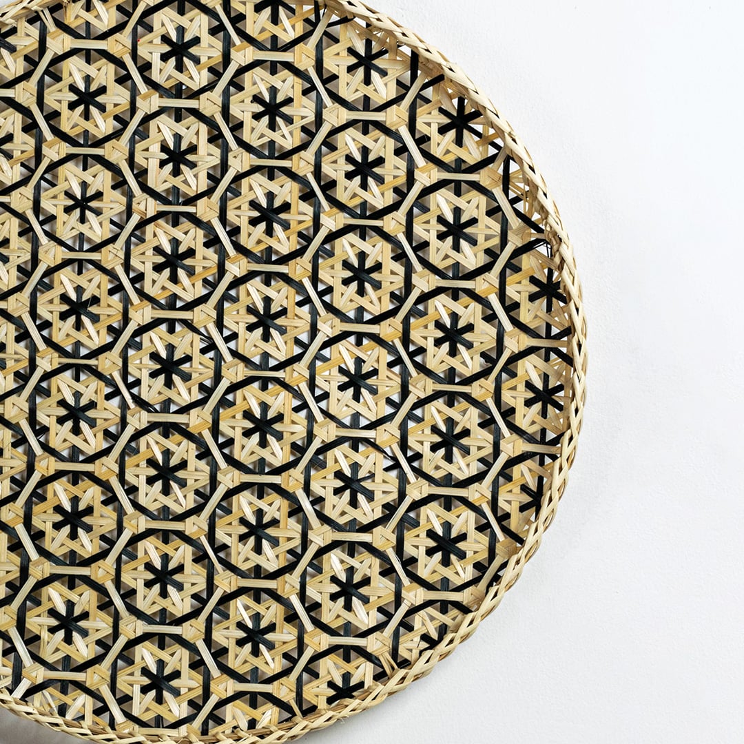 Closeup of handcrafted wall basket featuring black and natural star motifs highlighting intricate weaving and premium artisan detailing.