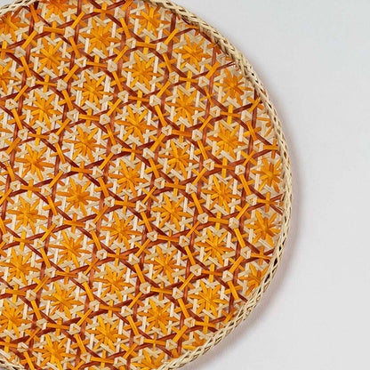 Closeup of orange woven wall basket with dense textured pattern showing fine craftsmanship natural material and vibrant decor appeal.