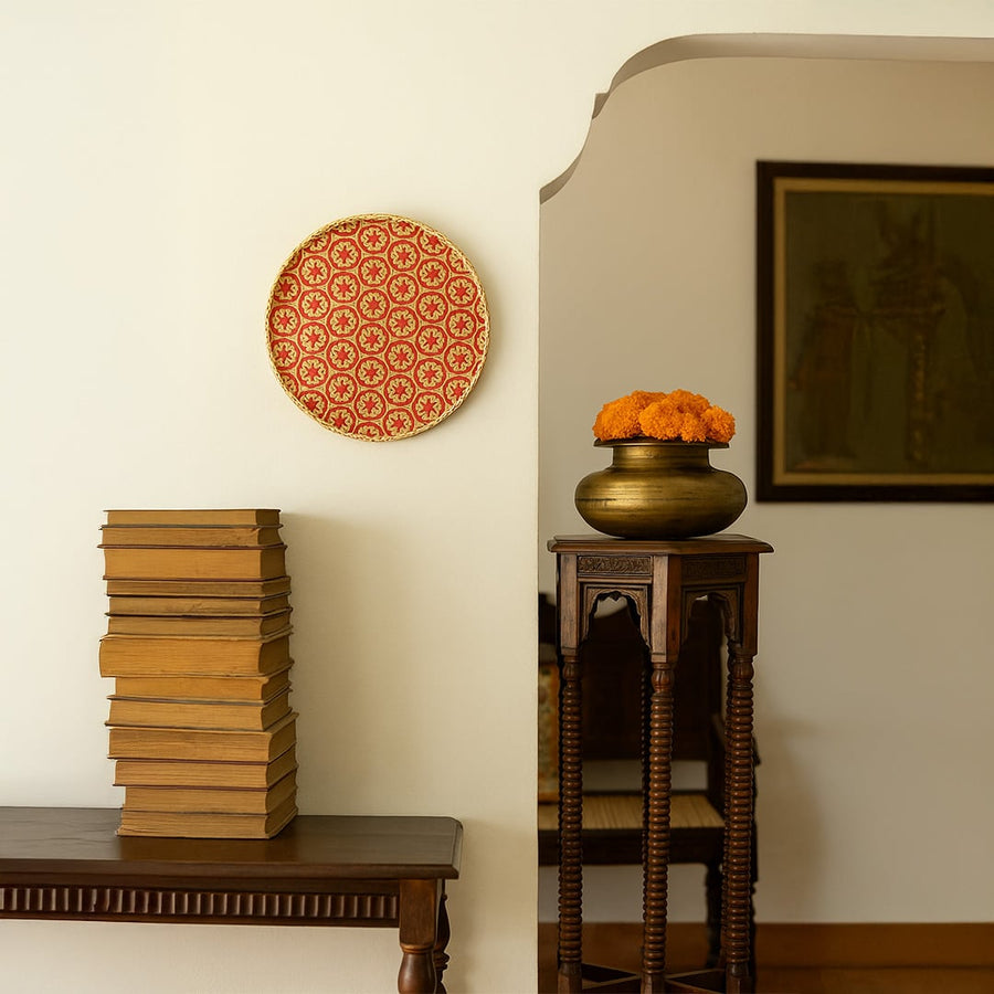 Red and natural woven bamboo basket with geometric floral pattern displayed as bohemian handcrafted wall decor accent.