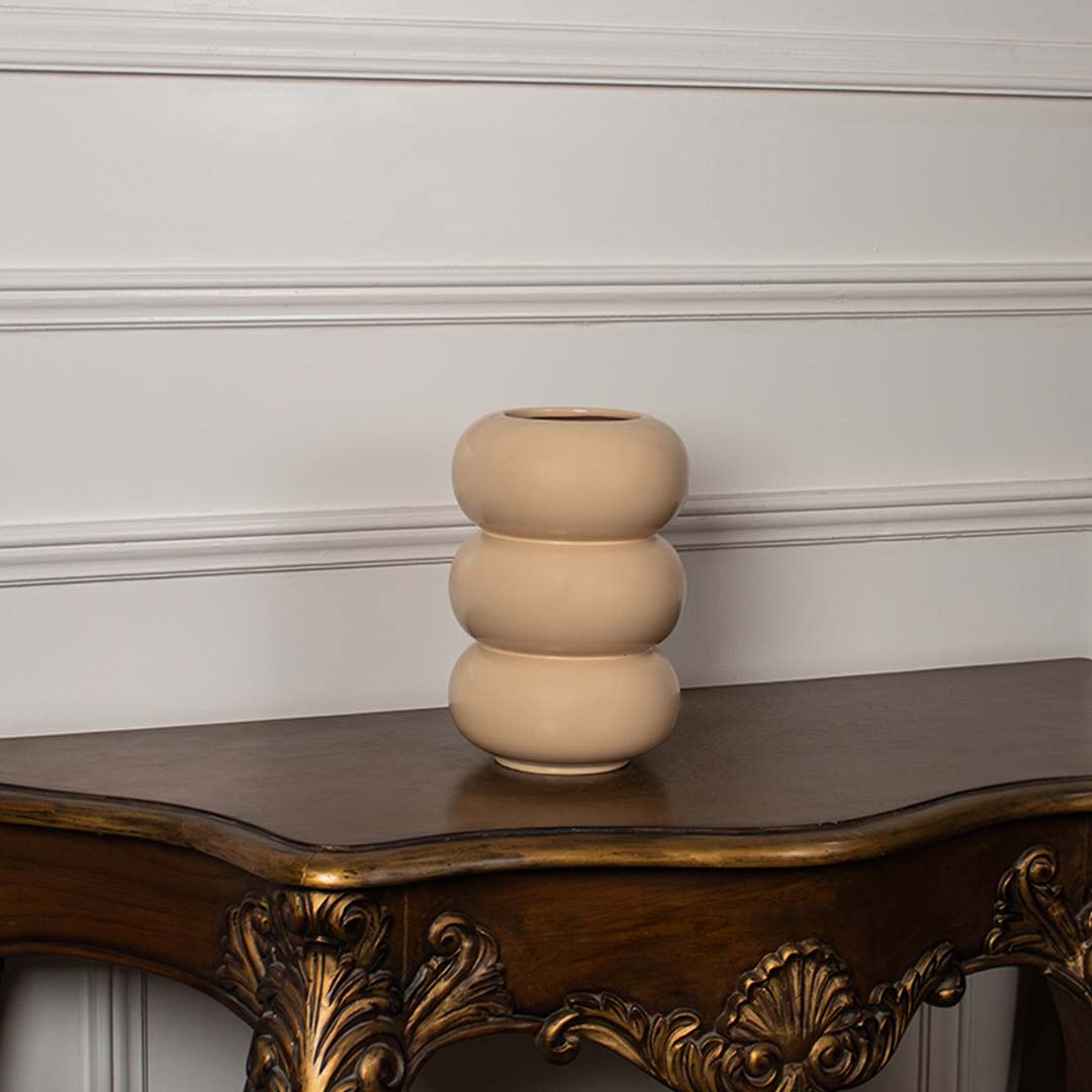 Soft peach cream ceramic stacked ring bubble vase displayed on a classic wooden console table for an elegant home decor.