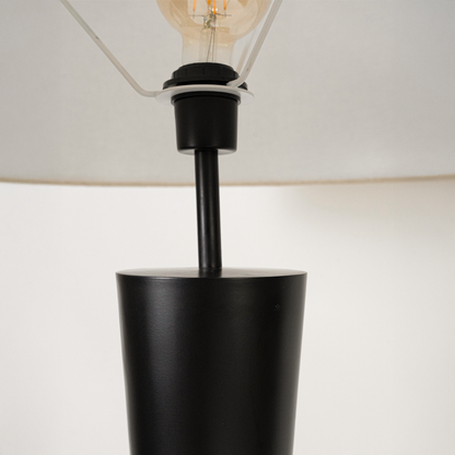 Closeup of modern floor lamp shade and upper stem showing smooth finish fabric texture and warm light spread highlighting premium craftsmanship.