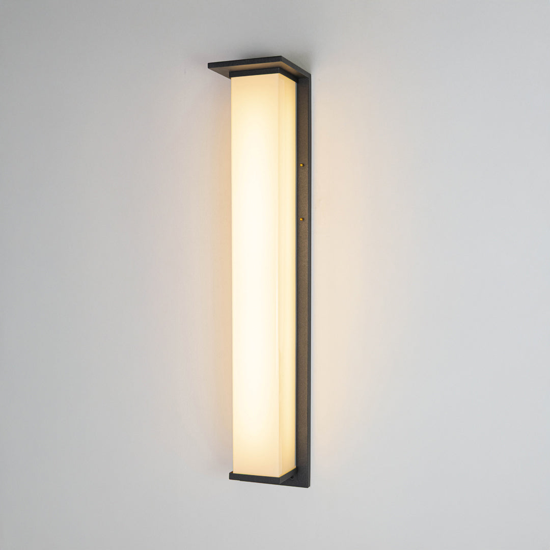 Black metal LED wall light on white background with frosted glass shade for minimalist modern decor.