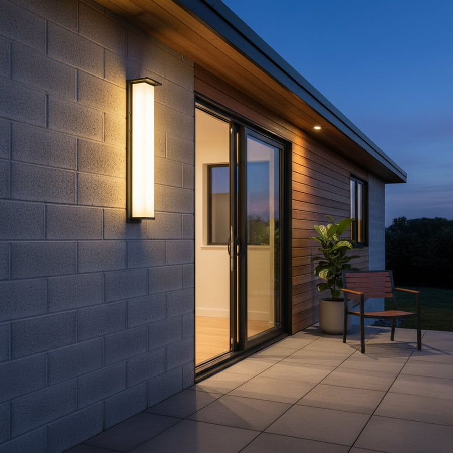 Tall modern wall light with black frame and frosted white shade illuminating exterior wall for elegant outdoor decor.
