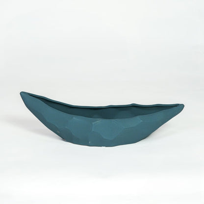 Teal ceramic decorative platter with sculpted curved design isolated on white background for contemporary table decor.