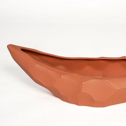 Close view of orange ceramic decorative platter featuring angular textured design and contemporary matte finish.