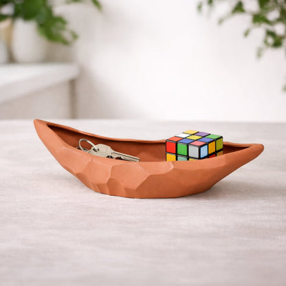 Orange ceramic decorative platter placed on table with decor accents adding warm artistic touch to living space.