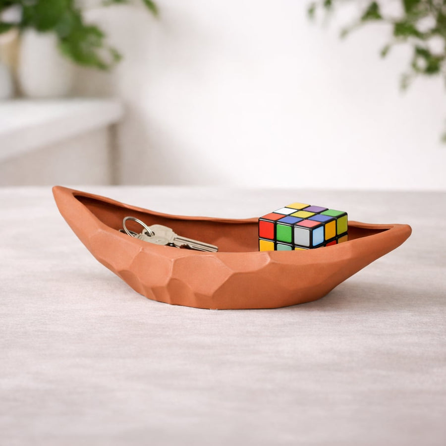 Orange ceramic decorative platter placed on table with decor accents adding warm artistic touch to living space.