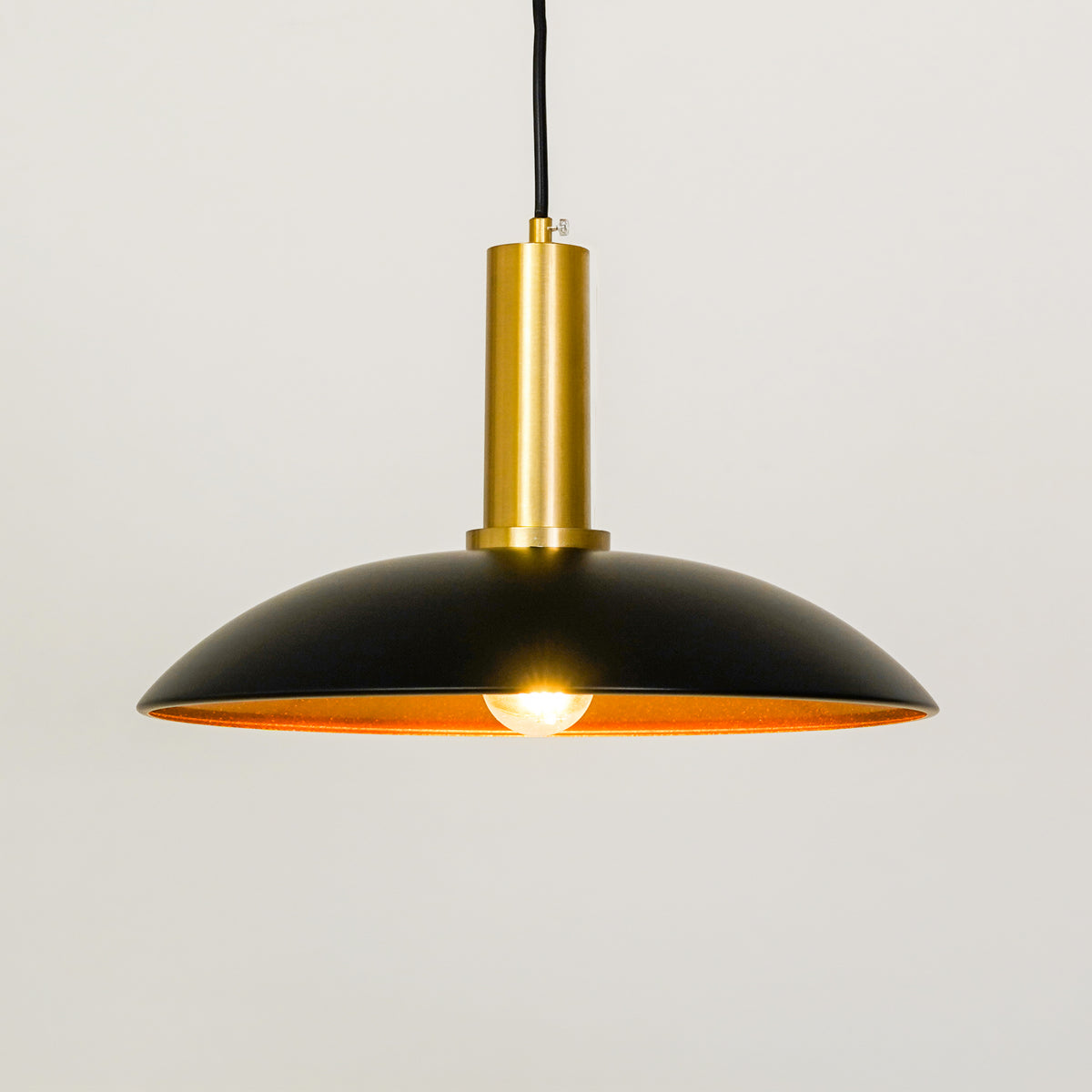White background image of barn style black gold metal lamp for elegant dining room decor styling with bright illumination.