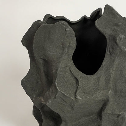 Close up view black sculptural ceramic vase showing organic textured surface matte finish decorative ceramic accent for home styling.