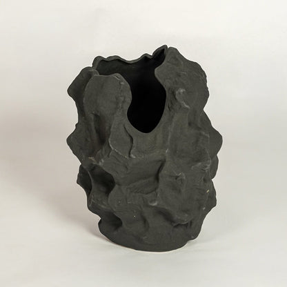Black decorative sculptural ceramic vase on white background modern home decor accent piece for table shelf console styling.