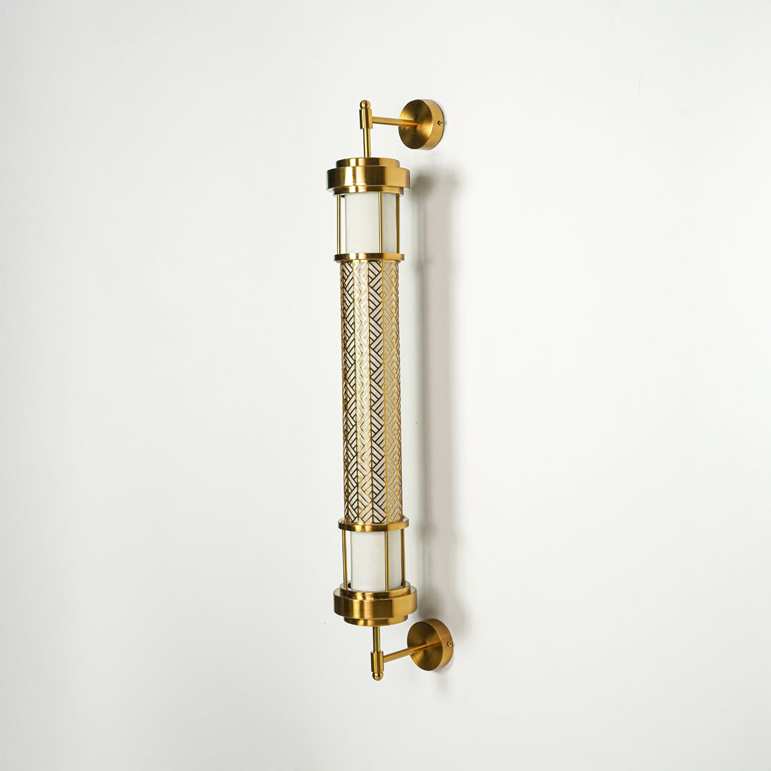 Modern gold wall sconce with cylindrical glass tubes and metal detailing on clean background perfect for contemporary interior decor lighting.