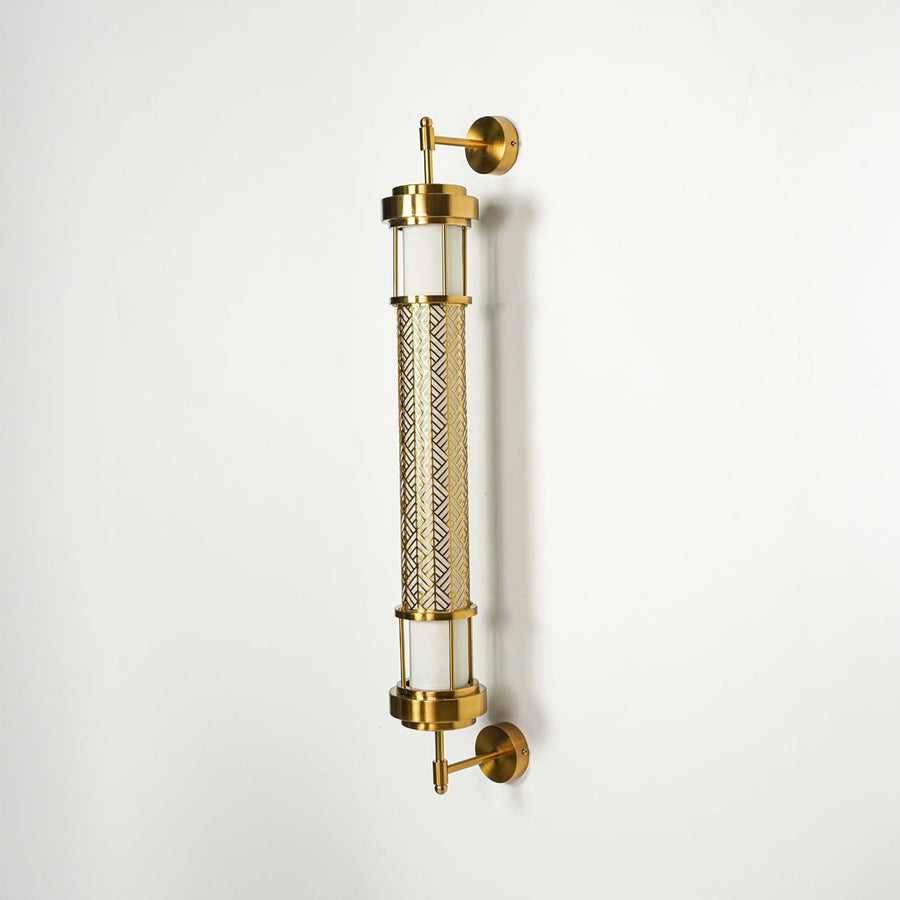 Modern gold wall sconce with cylindrical glass tubes and metal detailing on clean background perfect for contemporary interior decor lighting.