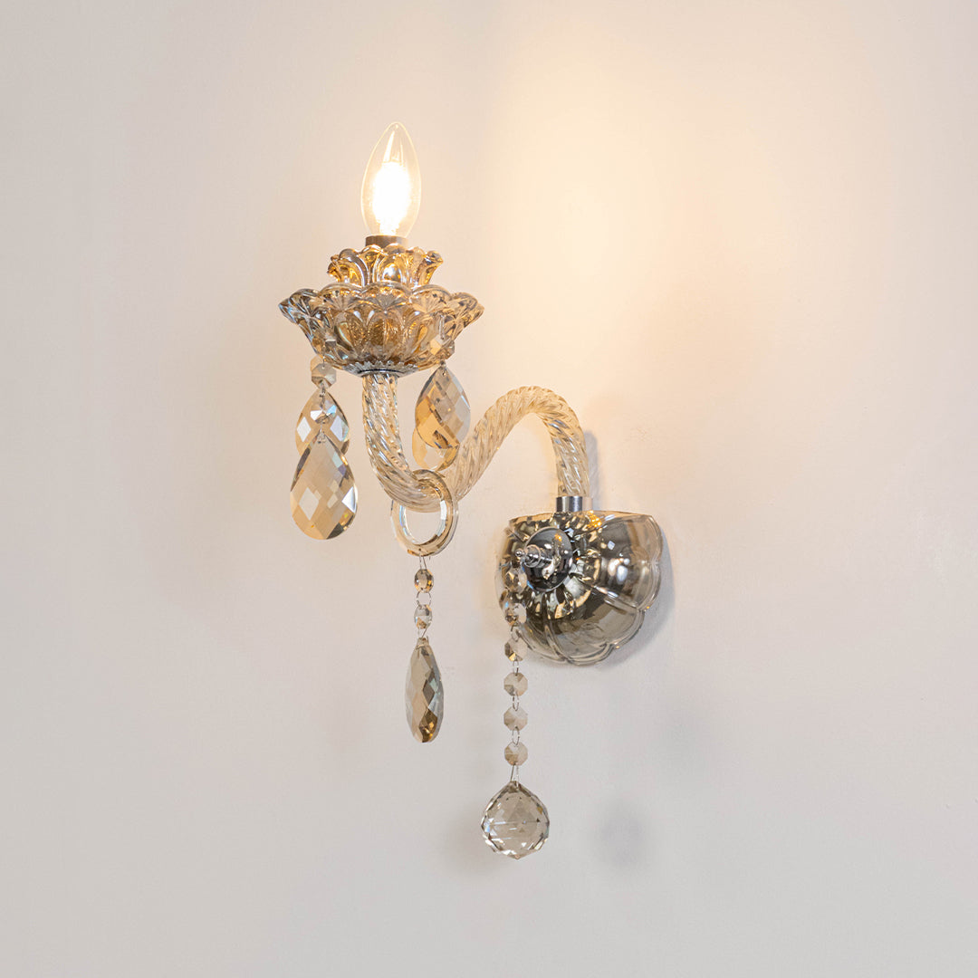 Decorative crystal wall light in gold finish with hanging crystals for bedroom or living decor lighting white background.