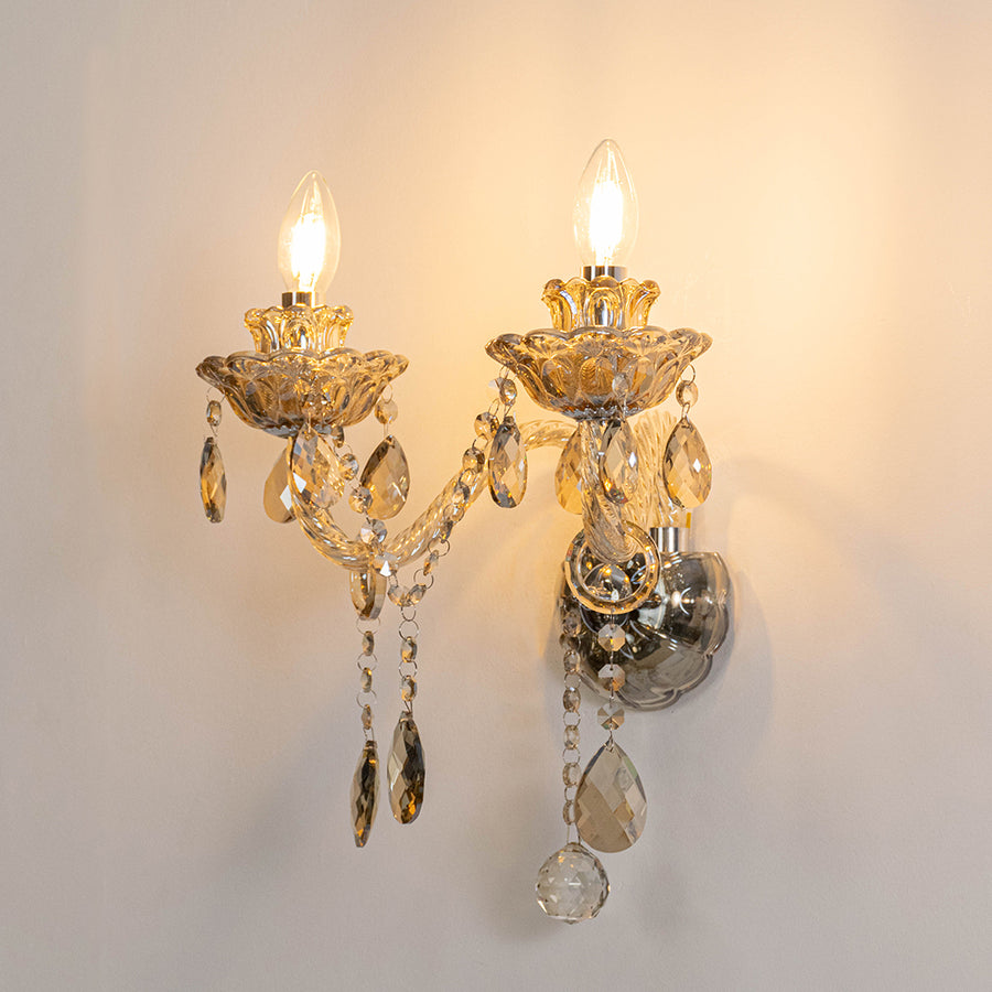 Elegant crystal wall light in gold finish with hanging crystals for bedroom or living room decor lighting white background.