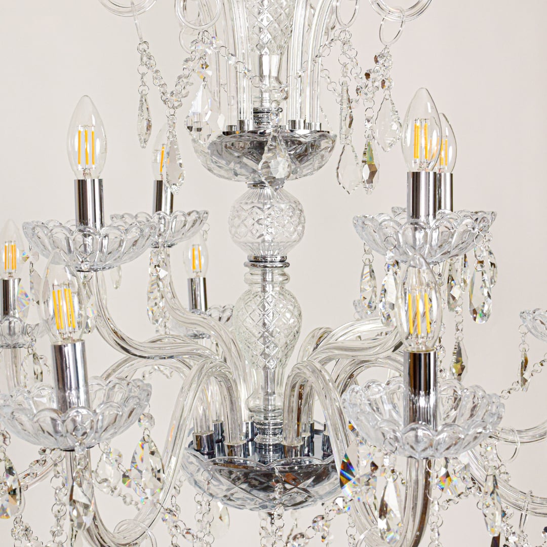 Closeup of large clear crystal chandelier with detailed crystal strands and curved arms perfect for luxury ceiling decor.
