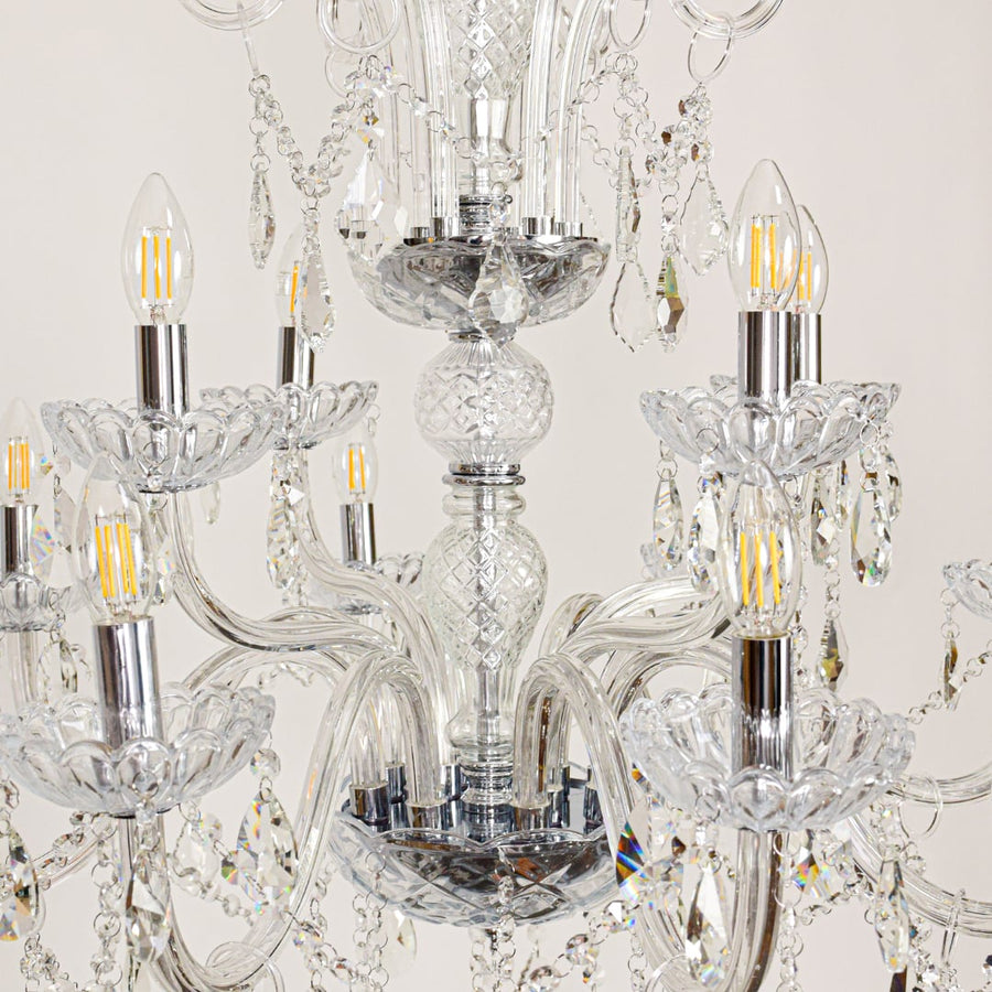 Closeup of large clear crystal chandelier with detailed crystal strands and curved arms perfect for luxury ceiling decor.