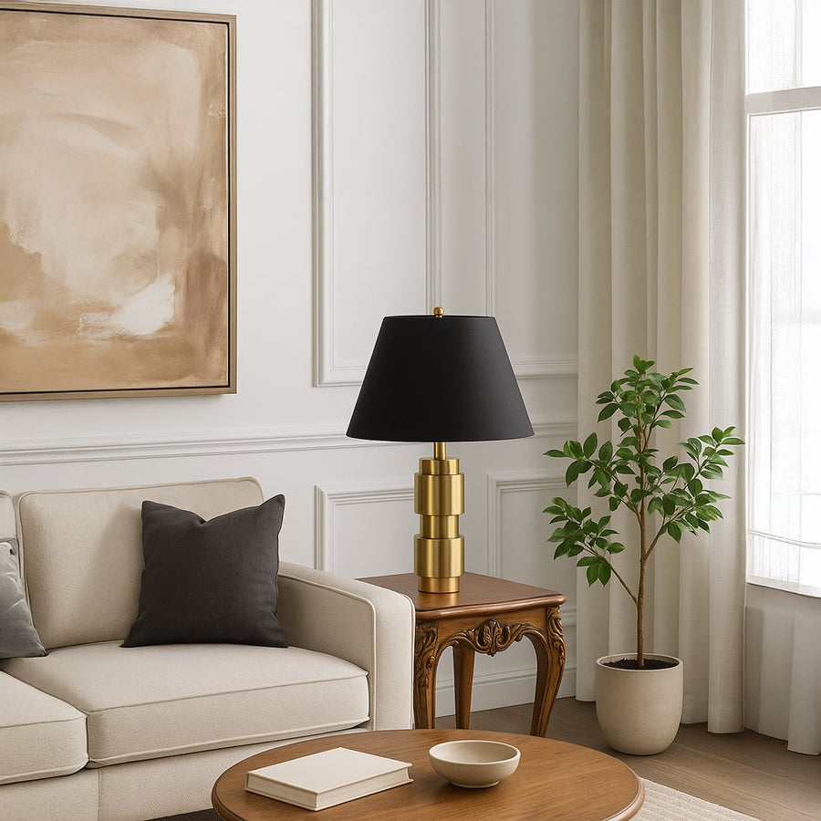 Elegant gold base table lamp with black shade styled on side table with plants for luxury home decor.