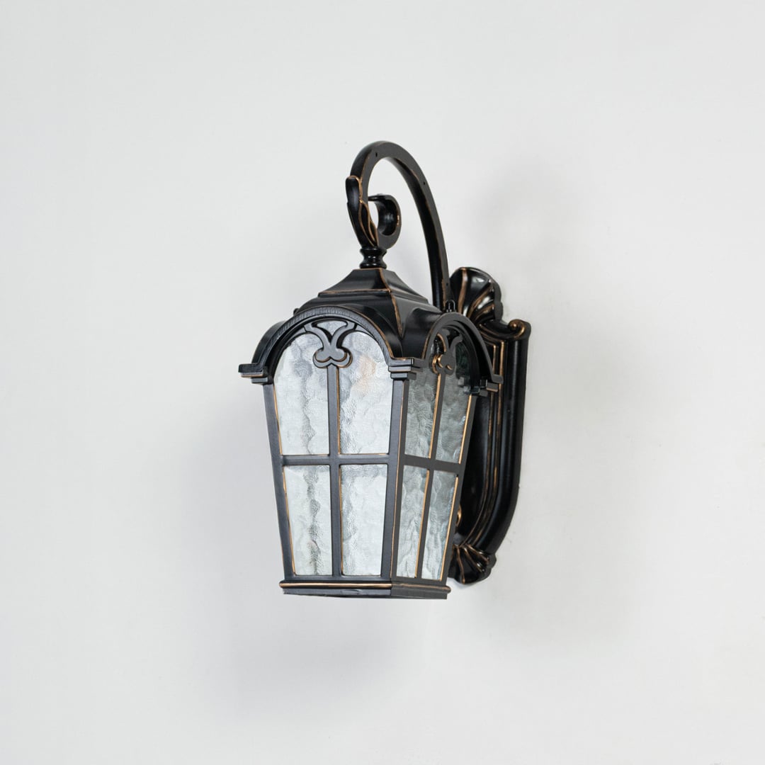 Light off white background displays black metal outdoor wall lantern with clear glass highlighting structure finish and design.