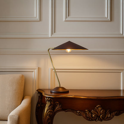 Gold metal table lamp with dark brown shade adding modern elegance to tabletop decor in a stylish living room setting.