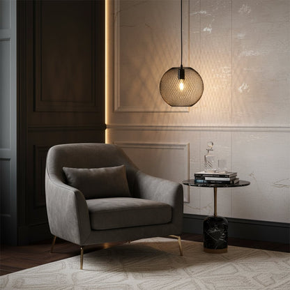 Modern glass pendant light casting warm ambient glow beside a lounge chair creating a cozy living room setting with elegant decor style.