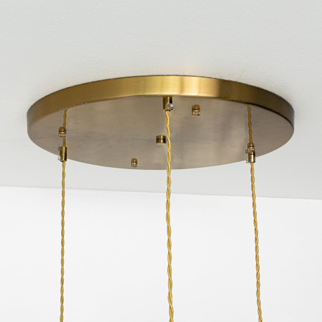 Gold metal ceiling canopy with hanging cords highlighting premium finish and minimalist styling.